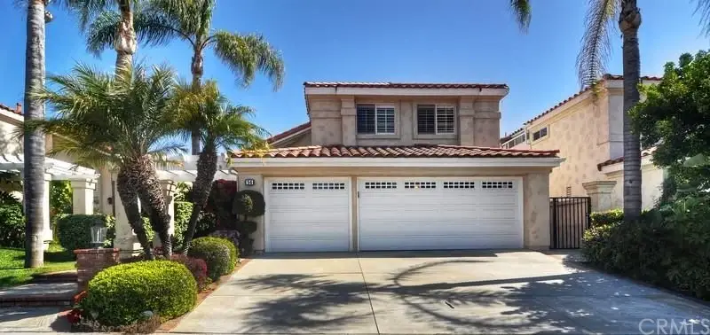 California real estate house with backyard, lawn, palm trees, and patio with outdoor furniture