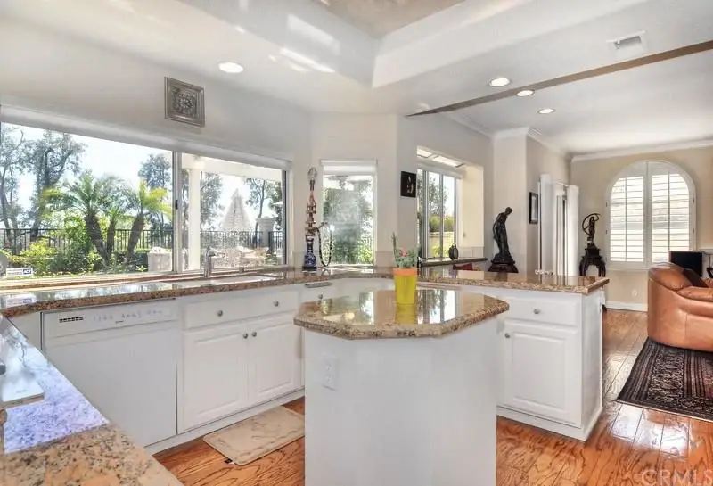 Kitchen with granite countertops, white cabinets, and windows
