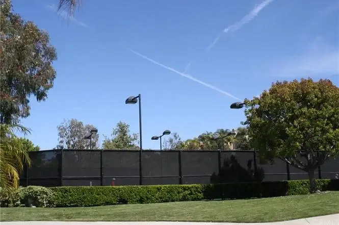 Black fence surrounded by greenery and trees