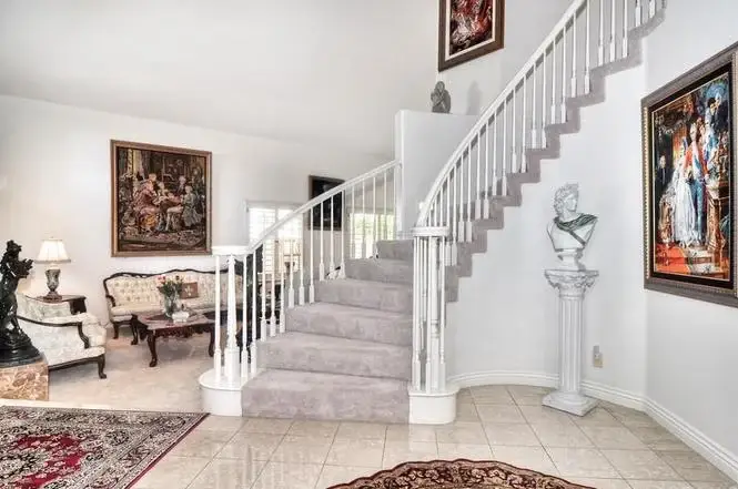 Interior with curved staircase, elegant furniture, and wall artwork