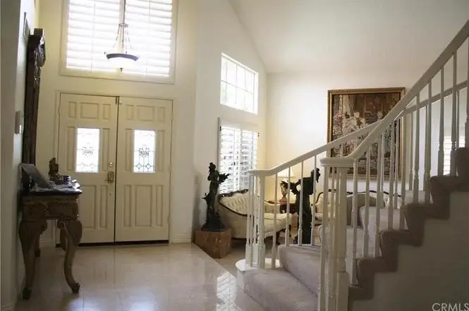 Entryway with staircase, decorative furniture, and windows