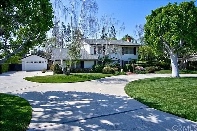 Luxury house California real estate with circular driveway, garage, green lawn, trees