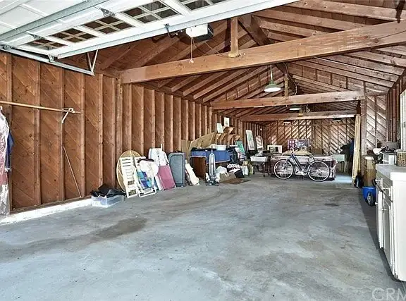 Garage with wooden walls, bicycles, and stacked furniture