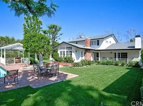 Luxury house California real estate backyard with swimming pool, patio furniture, and lawn