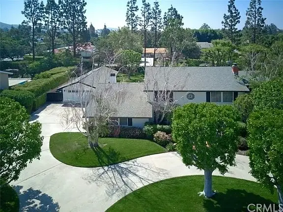 Luxury house California real estate with circular driveway, garage, trees, and landscaping