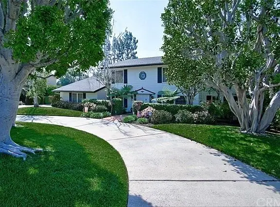 Luxury house California real estate with circular driveway, garden, and greenery