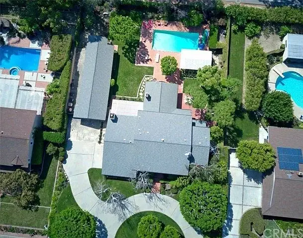 Residential property with two swimming pools, landscaped gardens, and multiple buildings