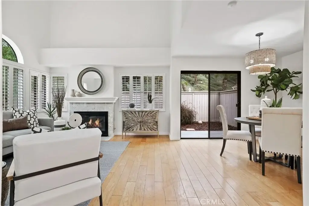 Living space with fireplace, hardwood floors, dining area with round table, and sliding doors to outdoor area