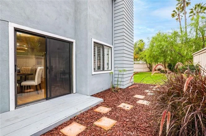 Side of house with sliding glass door, outdoor area, pathways, and pl