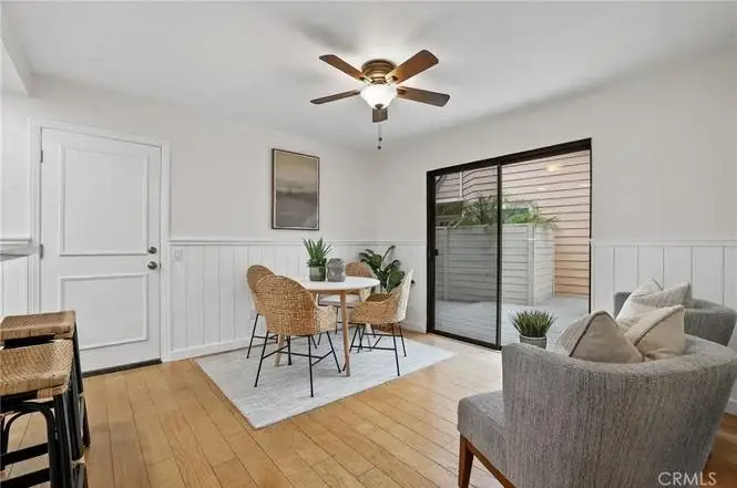 Dining area with round table, four wicker chairs, rug, and sliding doors to patio