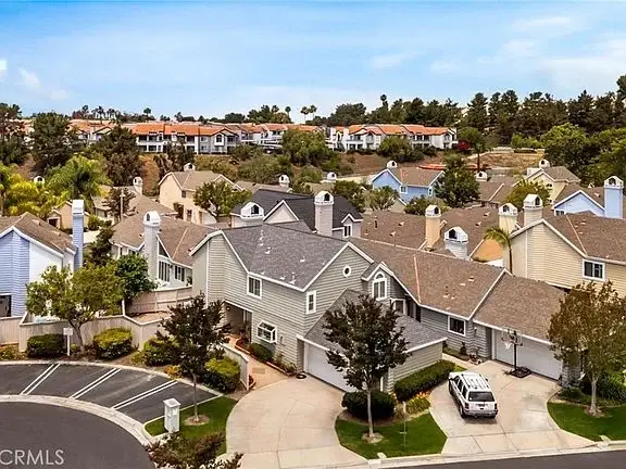 Aerial view of suburban houses California real estate with trees and cars on the street.