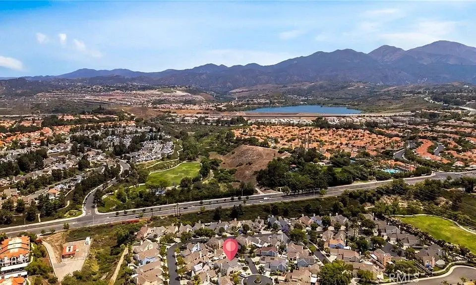 Aerial view of residential houses California real estate with mountains and water in the distance.