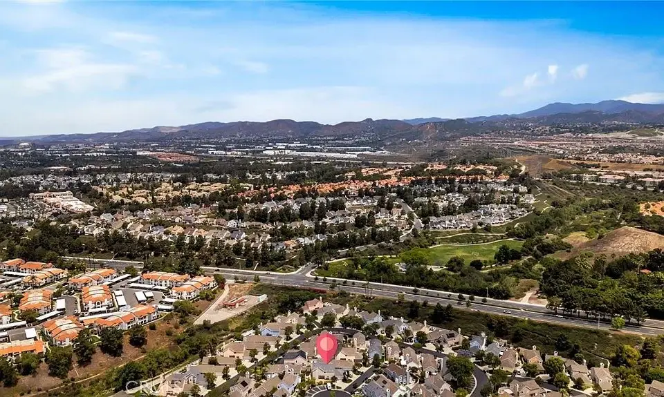 Aerial view of suburban houses and roads with hills in the background California real estate.
