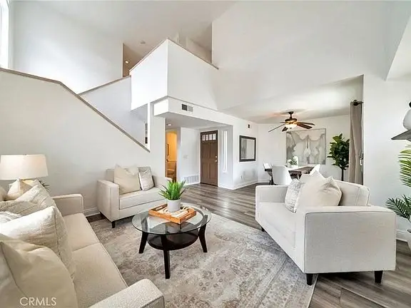 Living room with light sofas, round coffee table, rug