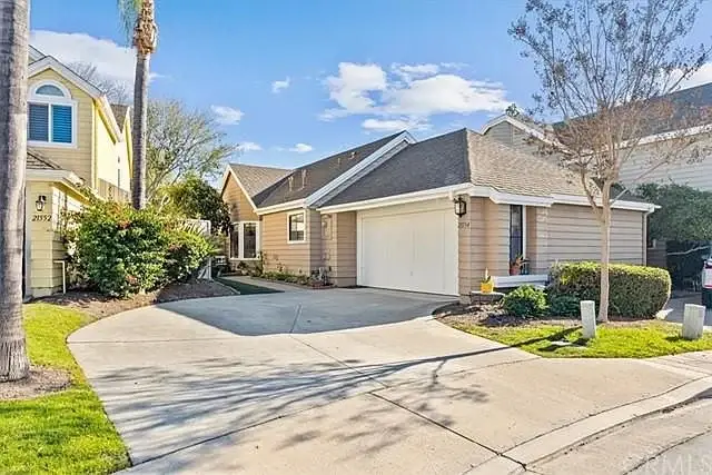 House California real estate with driveway, garage, palm trees, and landscaping