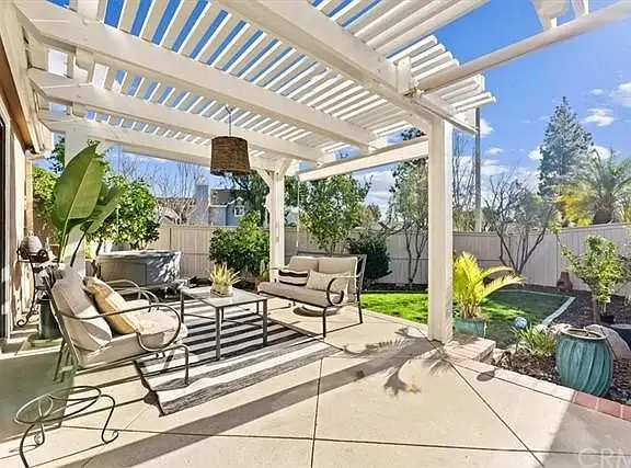Outdoor patio with seating, potted plants, and small garden