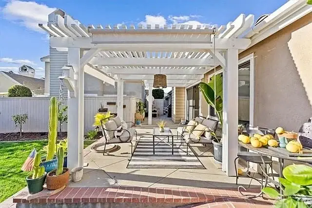 Patio with white frame, table with lemons, furniture, and plants