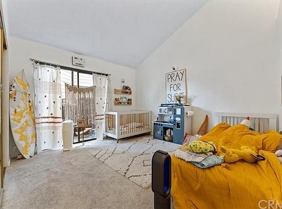 Kids room with toddler bed, crib, play area, shelves, and large windows