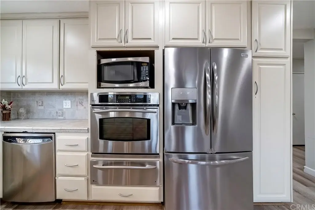 Kitchen with stainless steel appliances, light cabinets, and neutral countertop