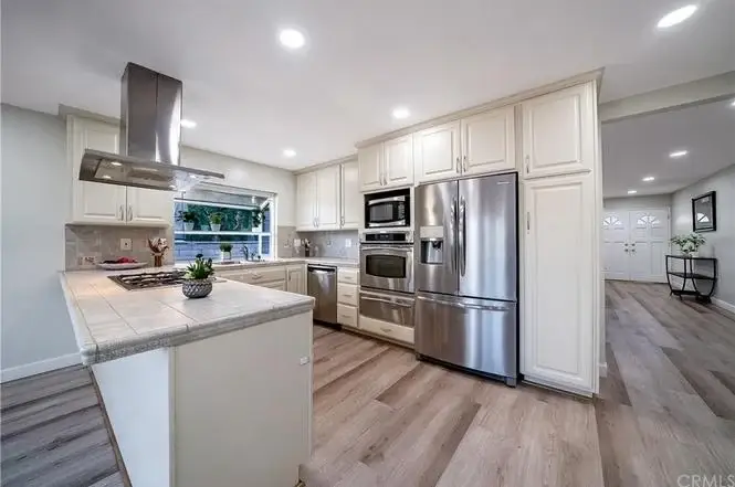 Kitchen with light cabinets, stainless steel appliances, gas stove, and island counter