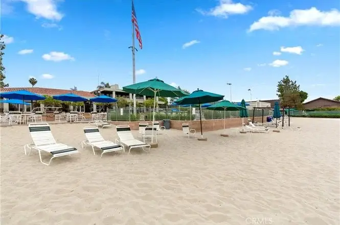 Beach with lounge chairs, umbrellas, volleyball court