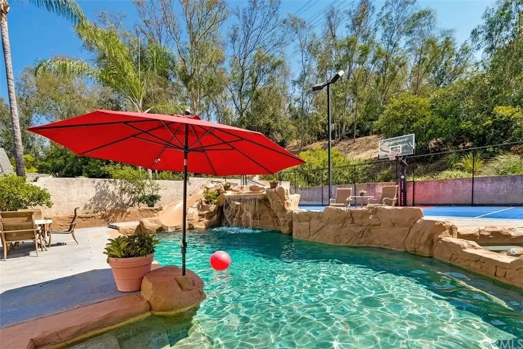 Luxury home in California real estate with a pool and a basketball court.