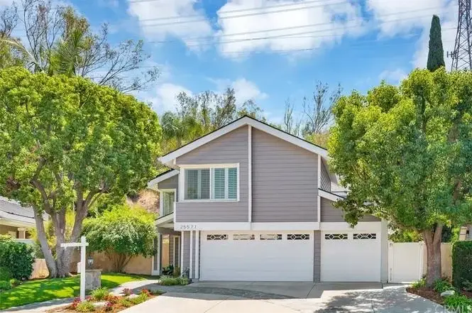 Luxury house California real estate with light gray exterior, large windows, and double garage