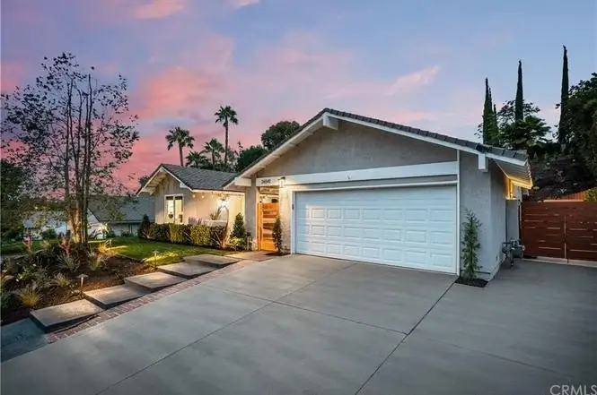Suburban home with two-car garage, landscaped gardens, and palm trees, California real estate