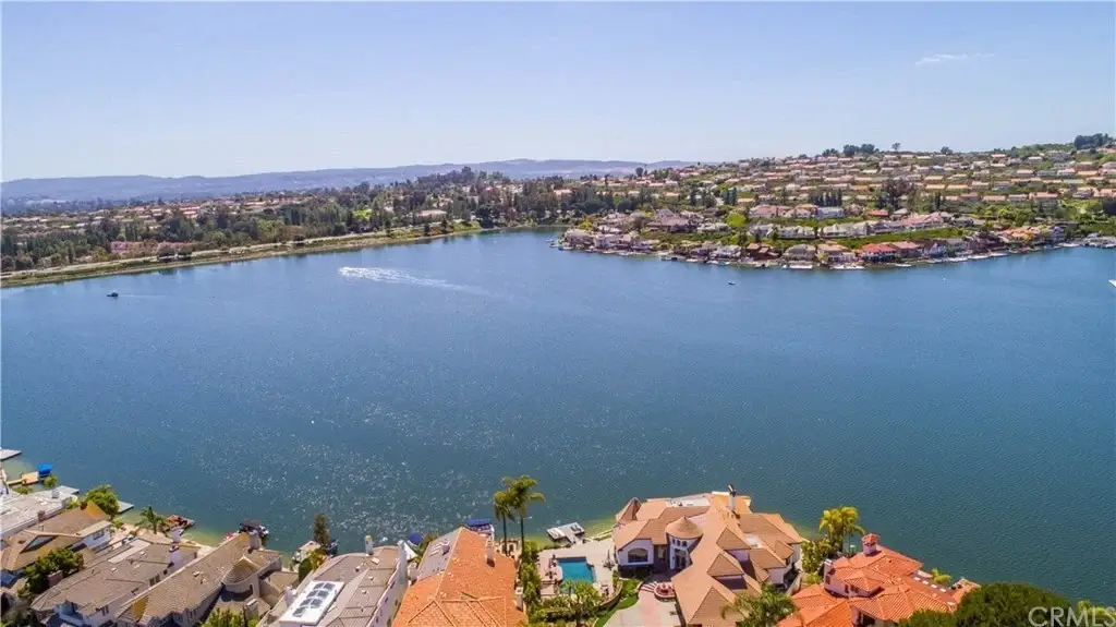 Aerial view of lake with houses, mountains, and California real estate