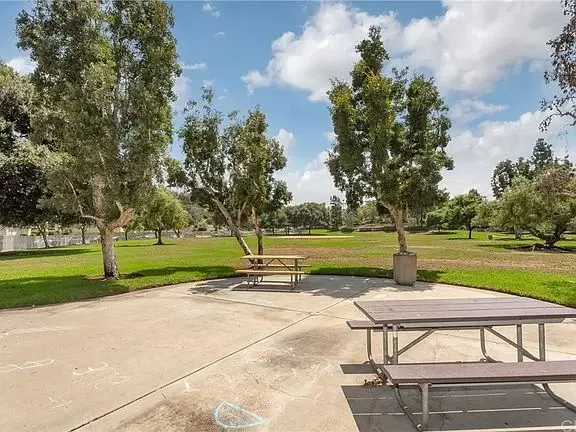 Park with green grass, trees, and picnic tables