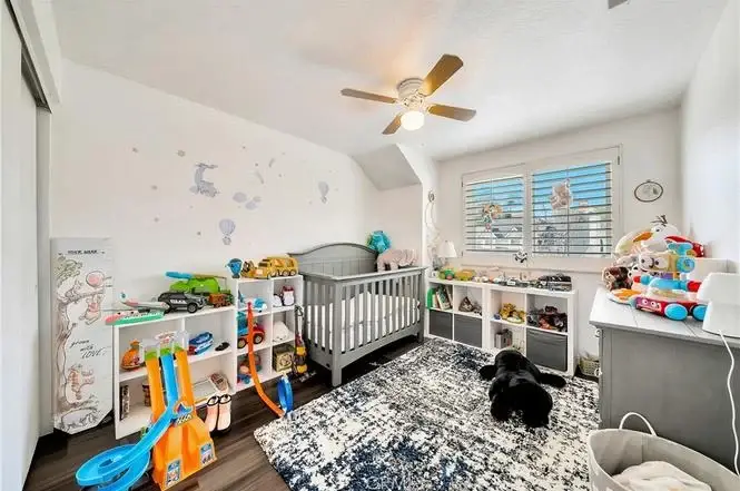 Nursery with crib, toys on shelves, and soft rug on the floor.