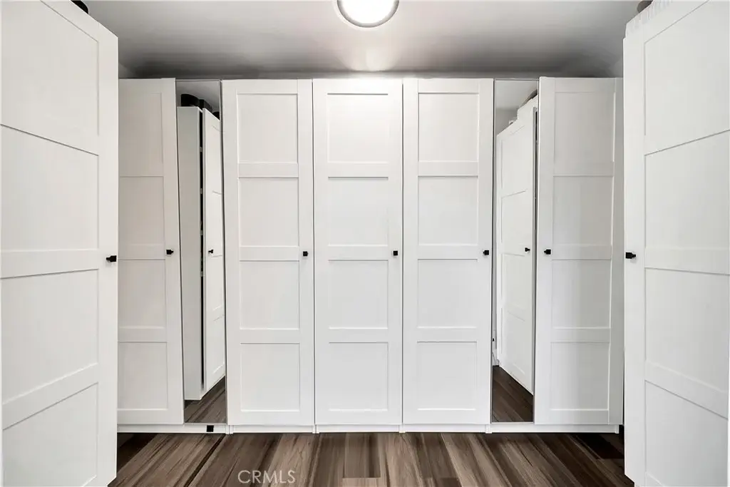 Room with white sliding closet doors and mirrored panels.