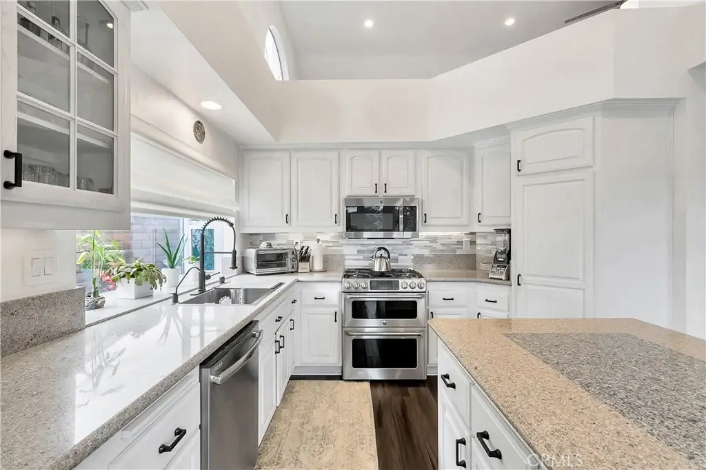 Kitchen with white cabinets, stainless appliances, and granite counter.