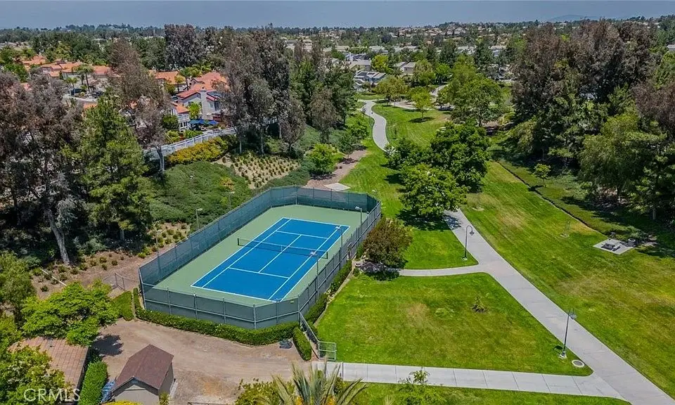 Aerial view of tennis court with trees and pathways in park