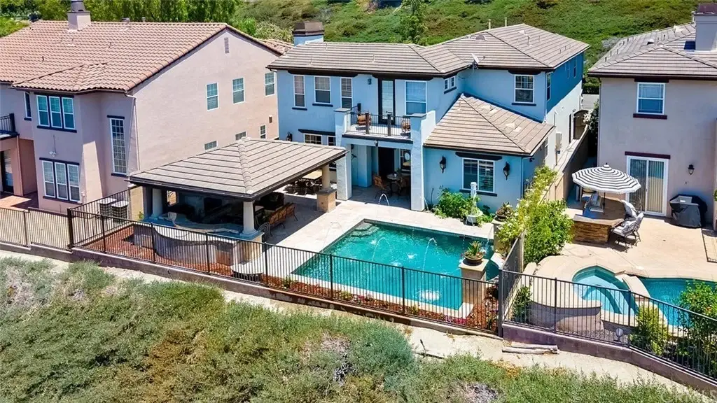 Aerial view of houses California real estate with pool and landscaped yards.