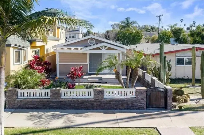 California real estate house with front yard, palm trees, and colorful plants