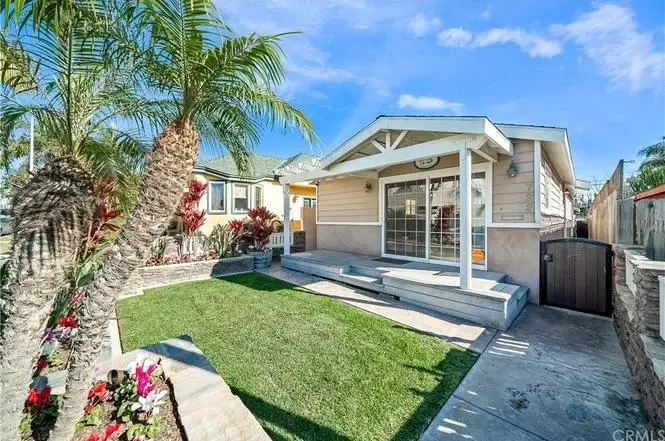 California real estate house with lawn, garden, palm trees, patio, and driveway