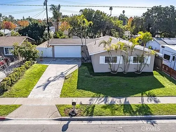 California real estate house with a green lawn and a mailbox in front.