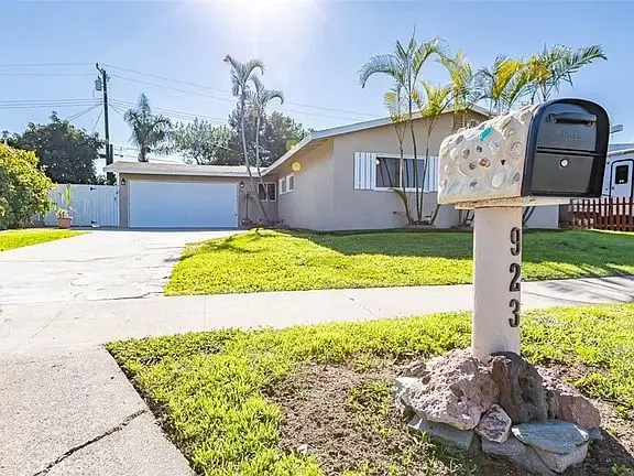 Front lawn with mailbox and driveway leading to a house California real estate garage.
