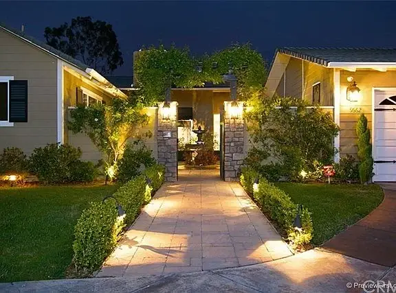 Pathway leading to house California real estate entrance with plants and walkway lights.