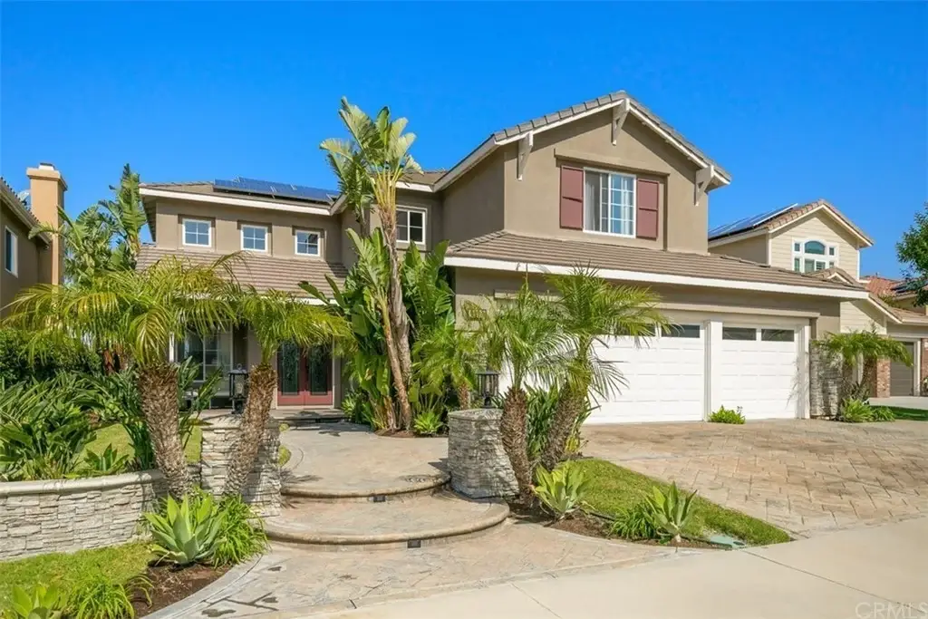 Luxury house California real estate with two-car garage, palm trees, and landscaped front yard